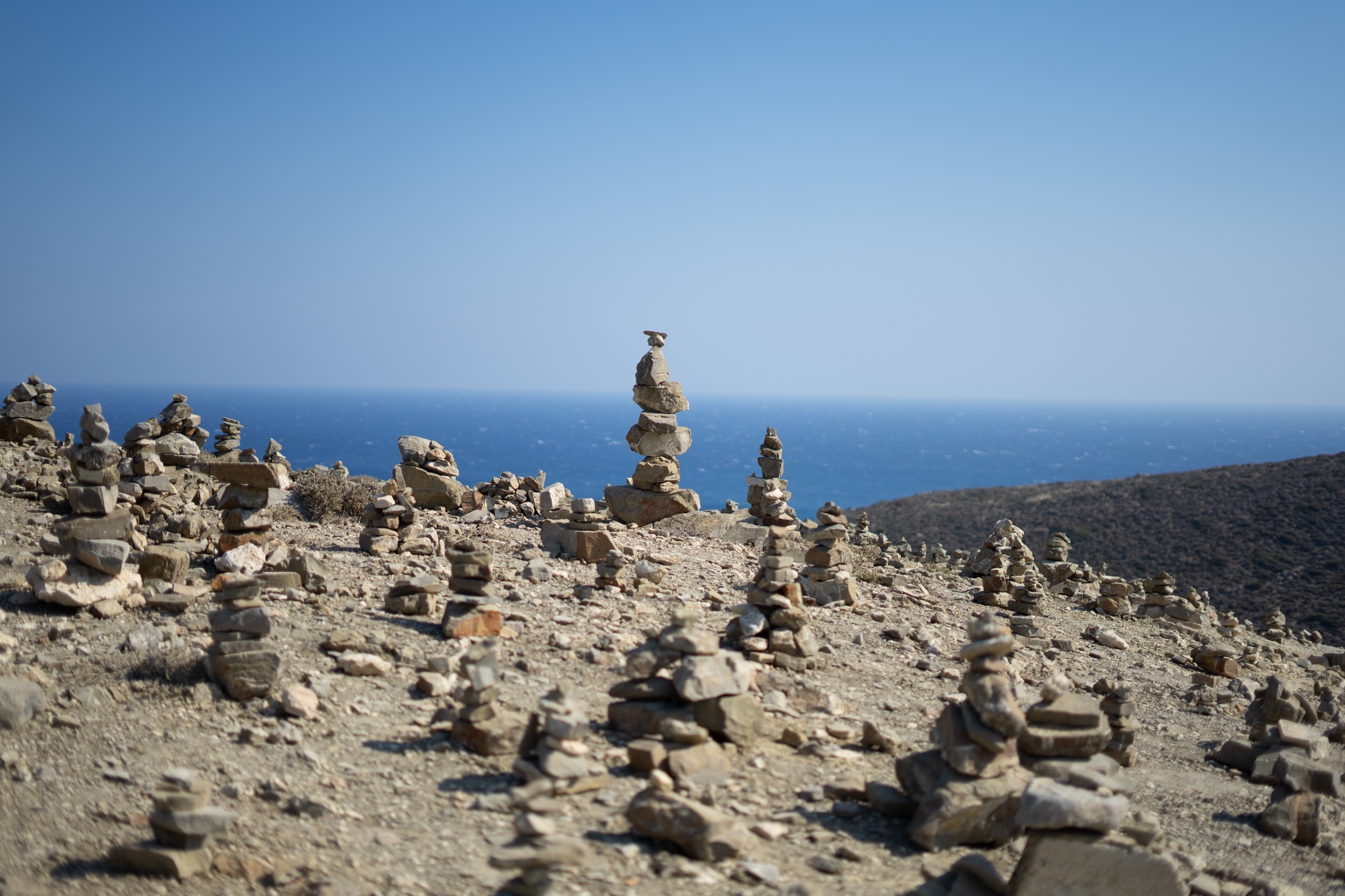 Stones on a rocky beach arranged into heaps and towers looking like building structures.