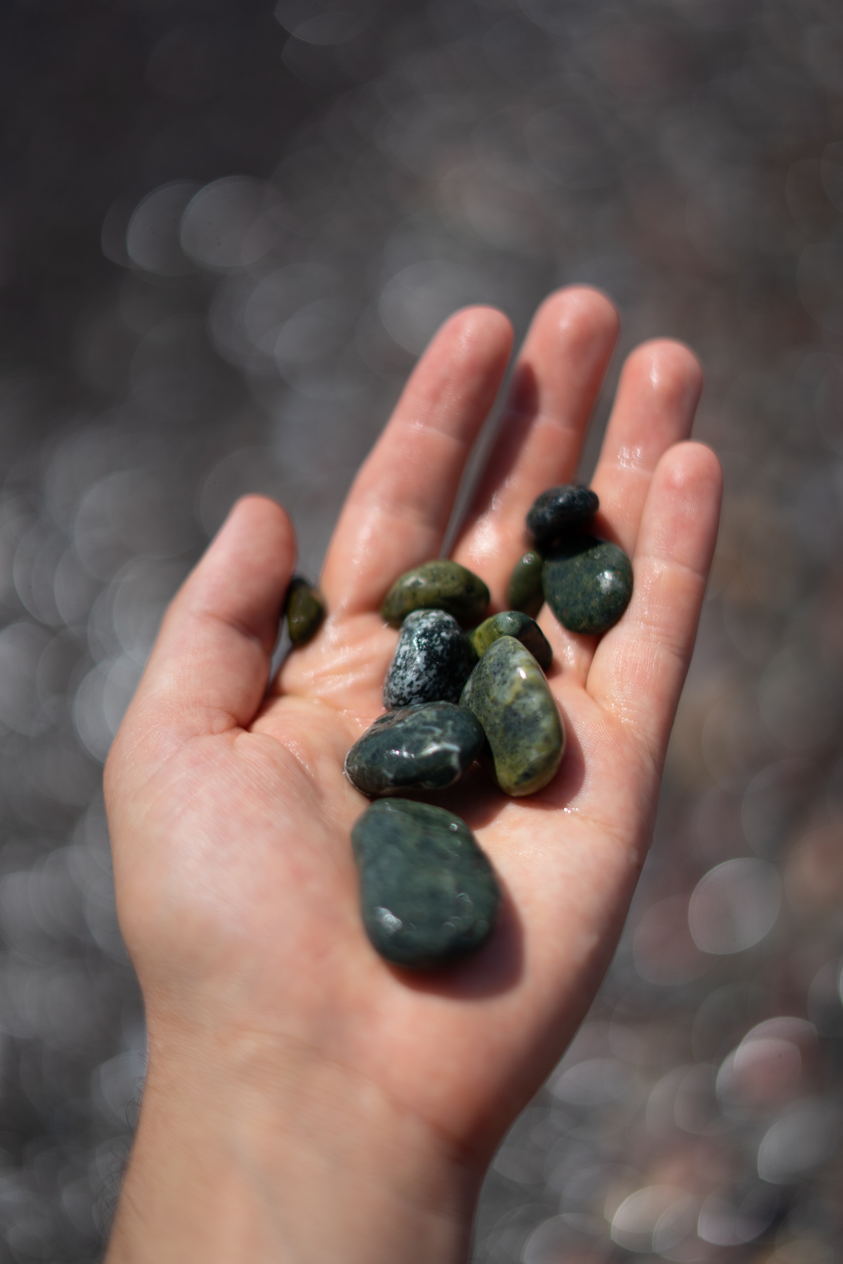 My hand holding beach stones