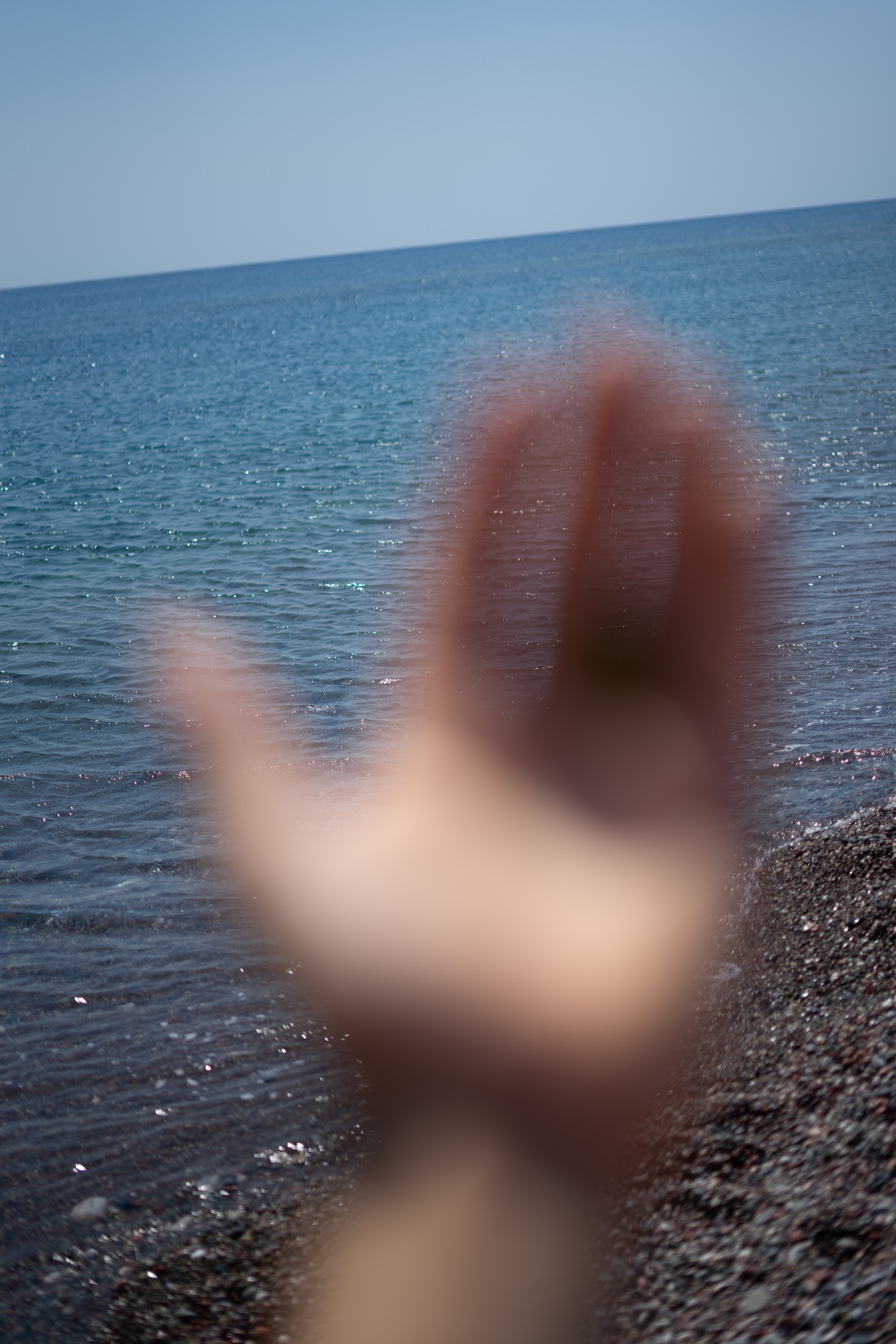 My hand out of focus in front of the sea